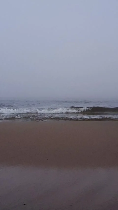 Calm sea waves on empty sand beach at misty morning Stock Footage 337851359