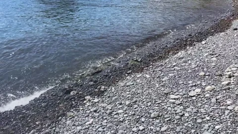 Calm sea waves on a pebble beach Stock Footage 240184614
