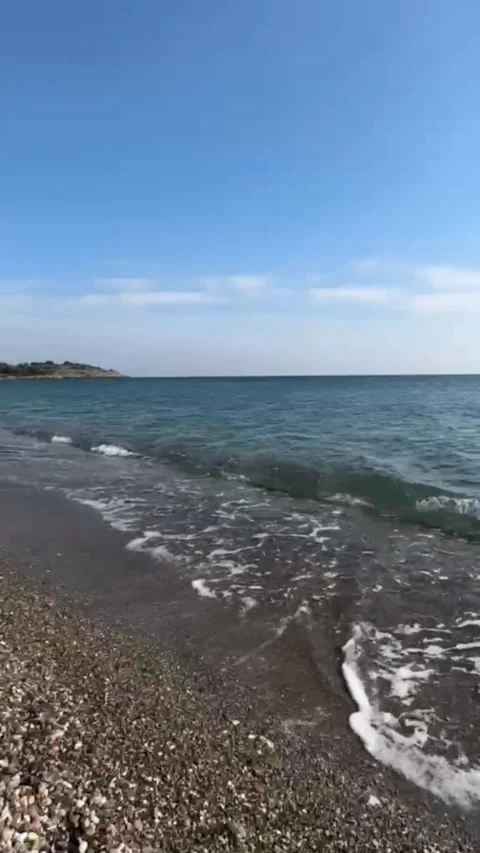 Calm Sea Waves on Pebble Beach Clear Blue Sky Nature Background Loop 動画素材 335638517