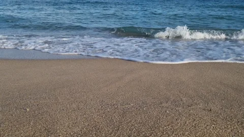 Calm sea waves rolling onto empty beach under blue cloudy sky Stock Footage 321269840