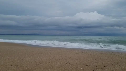 Calm sea waves rolling onto sandy Varna beach under clouds Stock Footage 320134245