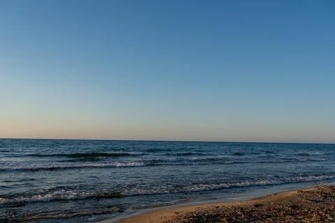 Calm sea waves rolling onto sandy resort beach coastline Stock Photos