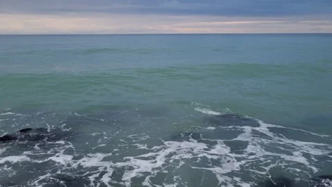 Calm Sea Waves Rolling Toward the Shore Under Cloudy Sky Stock Footage 320253629