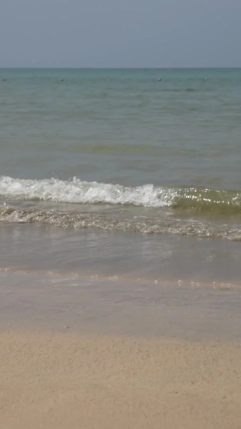 Calm sea waves on a sandy beach with blue sky Stock Footage 318715754