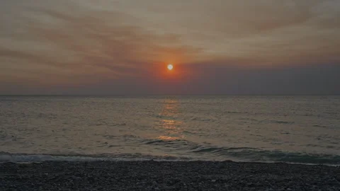 Calm Sea Waves at Sunset, Pebble Beach on a Warm Autumn Evening Stock Footage 303230205