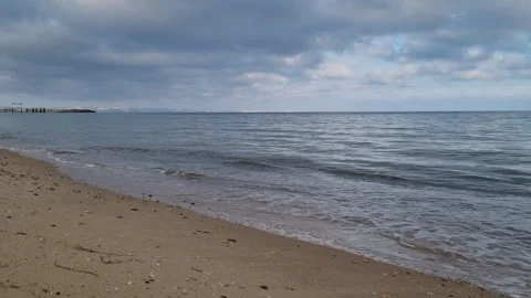 Calm sea waves touching sandy beach under cloudy autumn evening sky Stock Footage 322093107