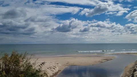 Calm sea waves under blue sky with bright white clouds Stock Footage 319573049