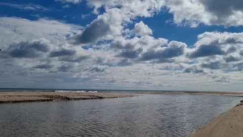 Calm sea waves under dramatic clouds and bright blue sky Stock Footage 319252467