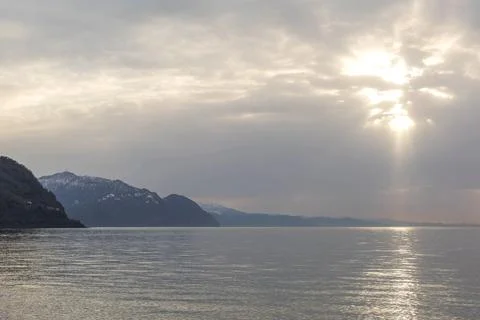 Calm seascape with soft sun rays breaking through clouds over a quiet horiz.. Stock Photos