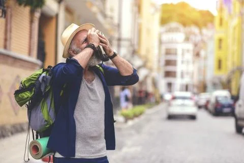 Calm senior man using camera in city Stock Photos