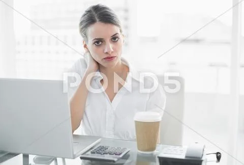 Calm serious businesswoman sitting at her desk Stock Photos