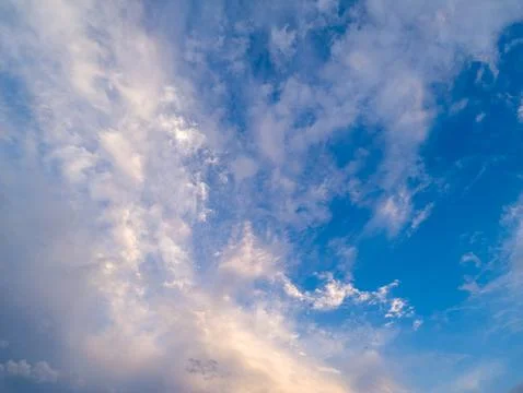 Calm sky with fluffy white clouds against vibrant blue Фото