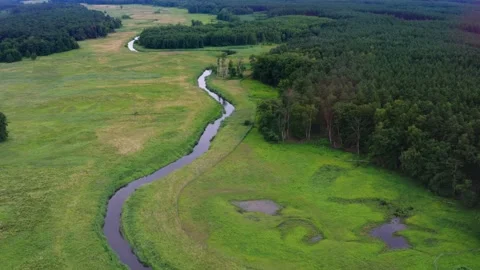 Calm small curving river between green fields Stock Footage 279515168