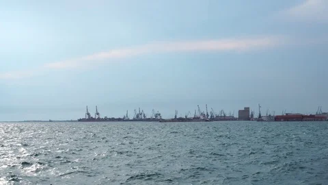 Calm small waves in deep blue sea on cloudy summer seaside day with huge modern Stock Footage 95392975