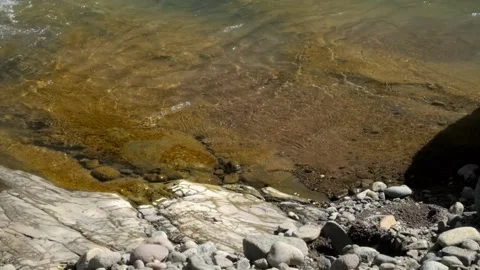 Calm small waves on the edge of a mountain river Stock Footage 336843576