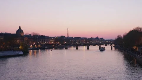 Calm static wide shot of Paris Seine river during sunset with touristic Stock Footage 244899661