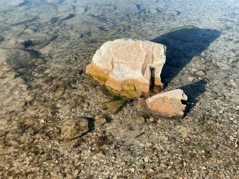 Calm stones river rocks reflection shadows still riverbed clear blue water Stock Photos