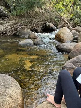 Calm stream with rocks and bare feet Stock Photos
