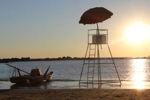 Calm sunset with boat and missing lifeguard Stock Photos