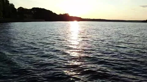 Calm sunset on the lake with play of waves and golden reflection. Stock Footage 312072462