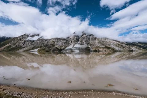 The calm surface of the lake and the reflection of the mountains by the lake Stock Photos