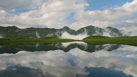 Calm surfase of a mountain lake with clouds reflections 스톡 동영상 89517546