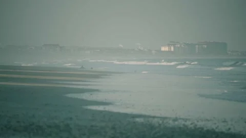 Calm tide waves rolling onto beach shore on a misty overcast morning Stock Footage 232498205