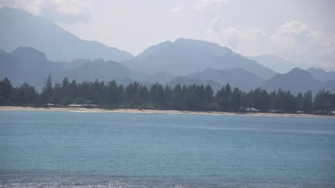 A calm tropical seaside view featuring traditional wooden gazebos overlooking th Stock Footage 263698929