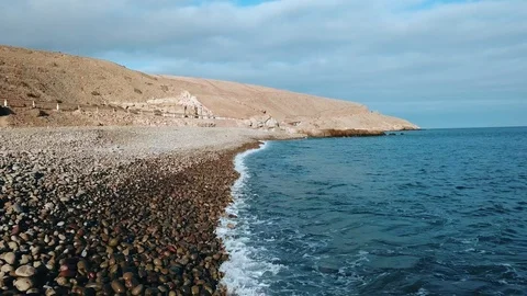 Calm turquoise ocean waves gently covering sand beach in sunset light. Camera Stock Footage 95715726