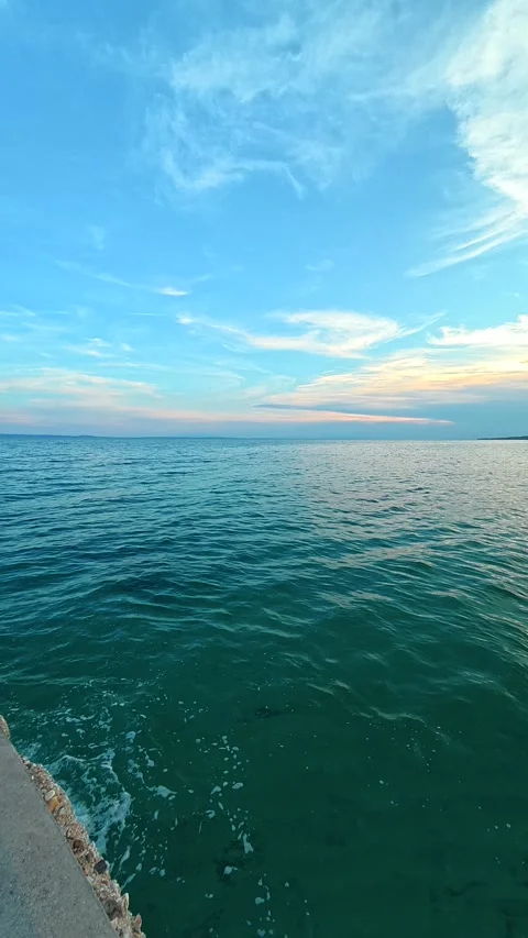 Calm turquoise sea meets soft blue sky. Lagomandra, Greece. Vertical Stock Footage 339628400