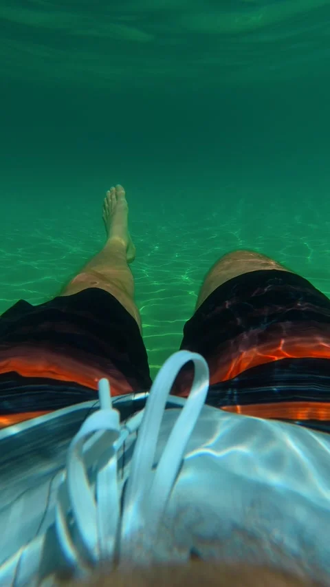Calm underwater view of person's legs. Trani Ammouda, Greece. Vertical Stock Footage 338358058