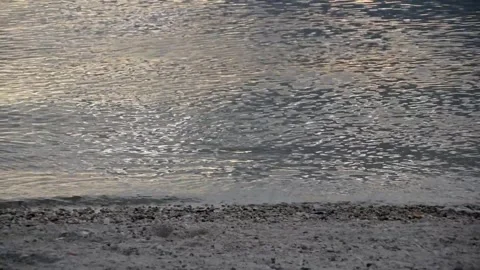 Calm water and small waves meeting the shoreline Stock Footage 328279861
