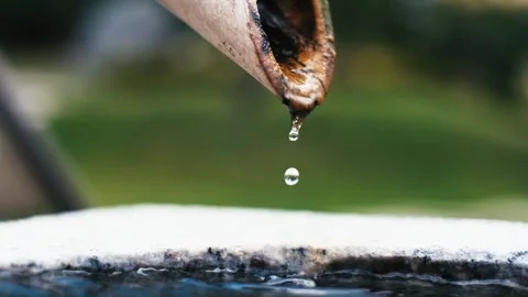 Calm water dripping from bamboo pipe into stone bowl, close up Stock Footage 340665098
