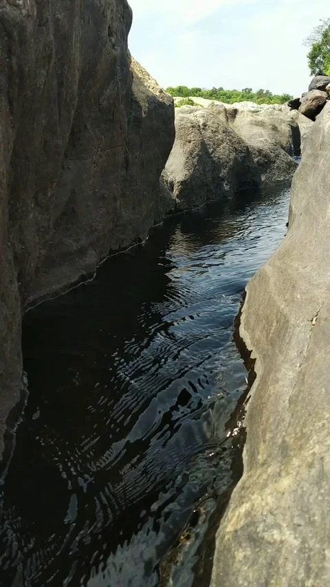 Calm water flowing between rocks Stock Footage 127477078