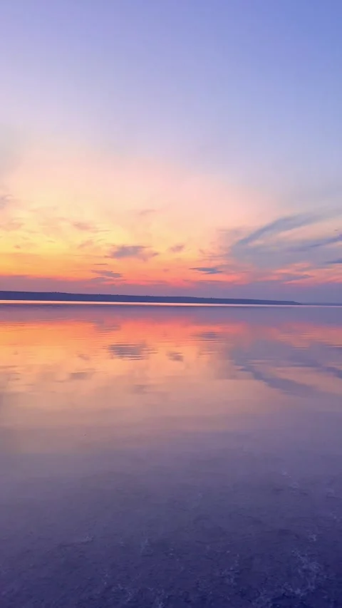 Calm Water Mirror Reflection of Pastel Sunset Sky at Dusk Stock Footage 345124096