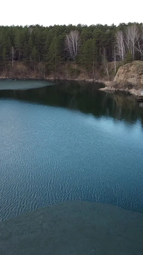 Calm water reflects forested cliffs Video stock 347499487