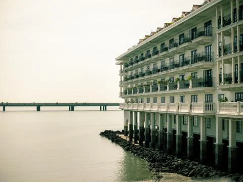 Calm water reflects soft light by a waterfront building Stock Photos