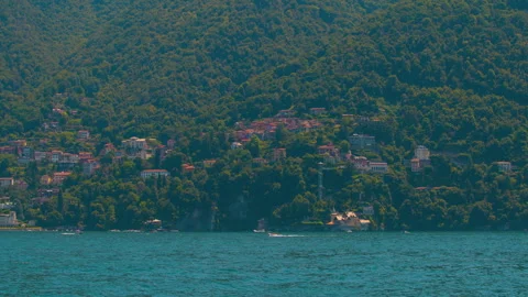 Calm water surface of Lake Como surrounded by green hills and mountain land Stock Footage 325545472