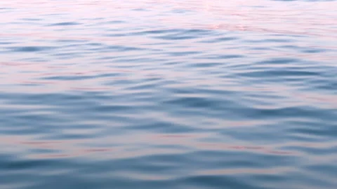 Calm water surface reflecting soft hues of pink and blue Stock Footage 306306577