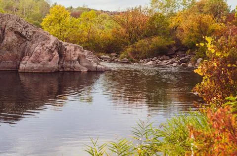 Calm water surface river flowing among granite rocks. autumn is bright season Stock Photos