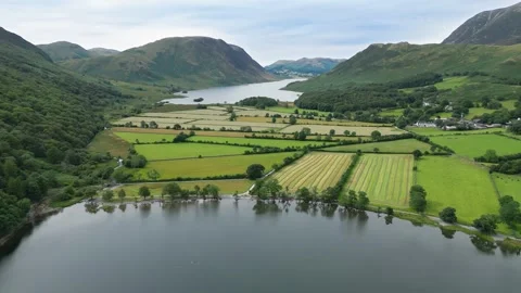 Calm waters mirror rolling green hills and farmland Stock Footage 345523527