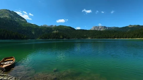 Calm waters reflect clear blue sky above. Black Lake, Montenegro Video stock 342968281