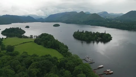 Calm waters reflect distant mountains and green islands Vidéo 345526226