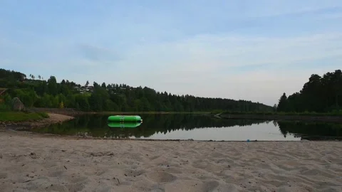 Calm waters reflect green float in a beach scene in Norway during early eve.. Stock Footage 340213935
