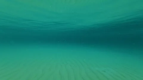 Calm waters reflect a vast, blue sky. Trani Ammouda, Greece Stock Footage 339617506