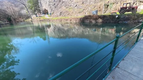Calm waters ripple beside a rustic wooden bridge. Balkan, Eastern Europe, POV Video stock 331455057