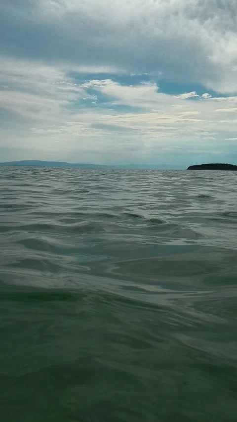 Calm waters ripple under a cloudy sky. Trani Ammouda, Vertical Stock Footage 340650609