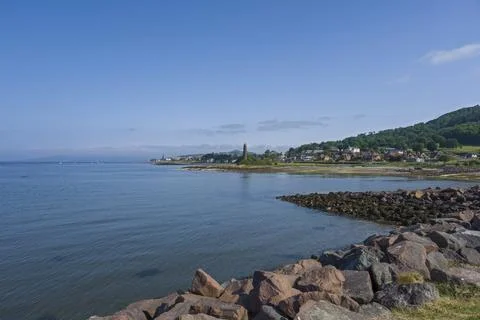Calm waters stretch toward a distant town of Largs. Stock Photos