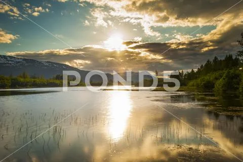 The calm waters on a unnamed lake in Portage Valley on a sunny, summer evening a Stock Photos