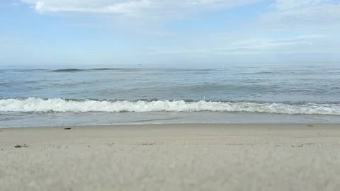 A calm wave rolls onto the sandy seashore Stock Footage 270575549